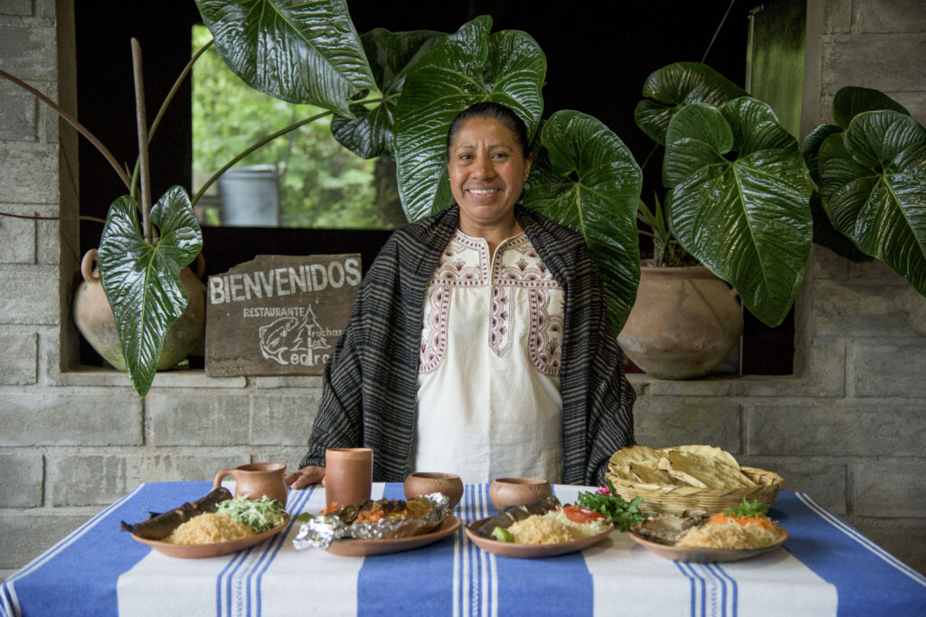cocinera tradicional en granja de truchas presentando sus platillos en santa maria huitepec sierra mixe oaxaca